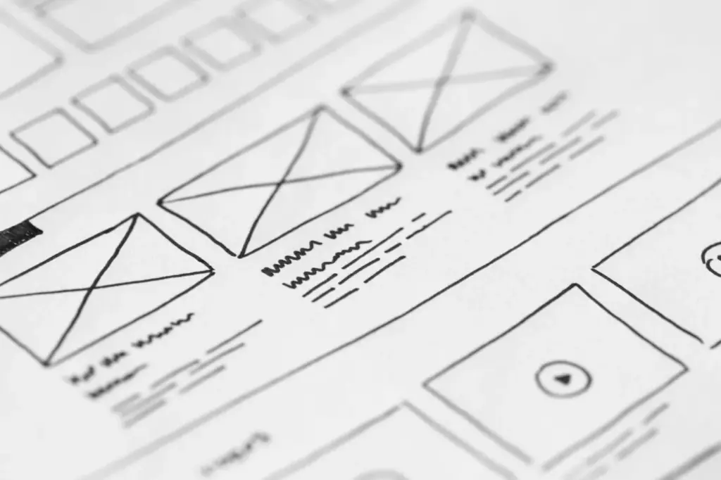 Hand-drawn website layout wireframes sketched in marker on white paper